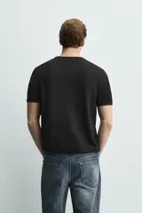 Camiseta de punto de corte regular, confeccionada en una mezcla de viscosa. Presenta cuello redondo y mangas cortas con acabados en rib.