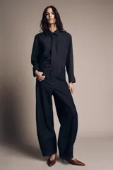 Jeans de tiro medio con corte balloon leg y largo al tobillo. Presenta diseño de cinco bolsillos, cintura con trabillas y cierre frontal con cremallera y botón metálico.