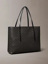 Cartera tote pequeña de Calvin Klein con estampado de monograma CK en color negro, asas de hombro dobles e incluye una cartera mini lisa a juego en el interior.