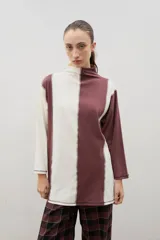 Polera de algodón con diseño bicolor en paneles verticales negros y bordó, cuello alto y tajos laterales.