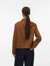 Campera corta de manga larga y color negro, con cuello clásico, cierre frontal de botones y bolsillos delanteros con solapa.
