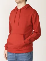 Sweater deportivo color rojo ladrillo, con capucha ajustable mediante cordones y bolsillo canguro frontal.