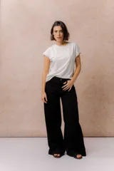 Pantalón de jean negro de corte wide leg, tiro alto y con costura vertical frontal.