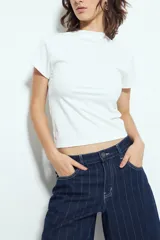 Top blanco de manga corta con cuello alto, corte ajustado al cuerpo.