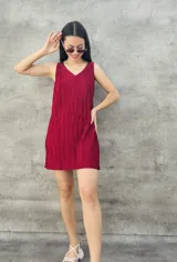 Vestido corto color borgoña con textura plisada, escote en V y sin mangas.