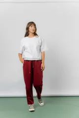Pantalón jogger color bordó intenso, de calce relajado, con cintura elastizada y lazo regulable. Cuenta con bolsillos laterales y detalle de cierre invisible.