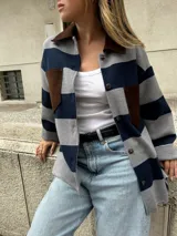 Camisa gris con rayas horizontales azul marino, cuello y bolsillos de cuero marrón, y cierre frontal con botones.