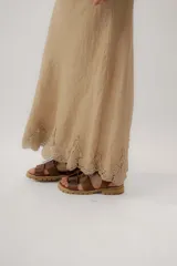 Pollera larga de lino color marrón con detalle de encaje en el ruedo.