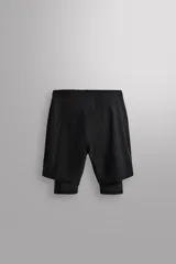 Pantalones cortos de entrenamiento 2 en 1 de Zara Athleticz, confeccionados en tejido técnico ligero con malla interior ajustada. Presentan cintura elástica con cordón de ajuste, bolsillos laterales con cierre de cremallera y aberturas en el bajo.