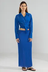 Camisa azul de manga larga con lazo en la cintura y botones nacarados.