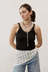 Musculosa negra de tirantes finos con detalles translúcidos en los bordes y diseño ajustado al cuerpo.