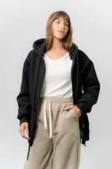 Campera deportiva con capucha de corte oversize, confeccionada en tejido suave con interior forrado en piel sintética. Presenta cierre frontal completo, bolsillos laterales y capucha amplia con cordones largos ajustables.