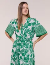 Vestido midi de estilo bohemio en color verde y blanco, con estampa floral, escote en V, cierre frontal con botones, mangas cortas amplias, cintura ajustable con lazo y volado en el bajo.