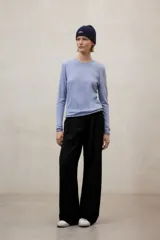 Pantalón negro de tiro alto, corte ancho y pierna recta, con pliegues frontales.