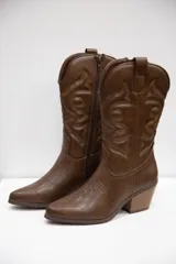 Botas texanas de caña media en color marrón, con diseño bordado y terminación lisa. Presenta punta fina, taco medio ancho y cierre lateral interno.