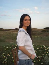 Blusa blanca de lino, de manga corta, con cuello marinero amplio decorado con estampado azul.