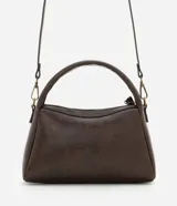Cartera pequeña de diseño estructurado color marrón, con asa corta fija y correa larga desmontable. Cuenta con cierre superior de cremallera y detalle de tiras decorativas en el lateral.