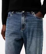 Pantalón de jean para hombre de corte recto, con lavado vintage y efecto desgastado. Posee cintura con presillas, cierre frontal con botón y cierre, además de bolsillos funcionales.