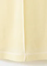 Remera de algodón color amarillo claro, con cuello redondo, manga corta y costuras pespunteadas a la vista en el frente y sisas.