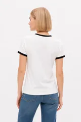 Remera de algodón blanca de manga corta estilo ringer, con cuello y puños en contraste negro. Presenta un estampado frontal con el número '28' relleno de encaje y la inscripción 'San Francisco Sports Club'.
