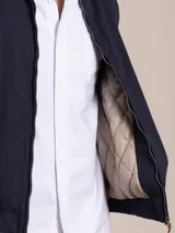 Campera azul marino con cierre frontal, cuello camisero y logo bordado en el pecho.