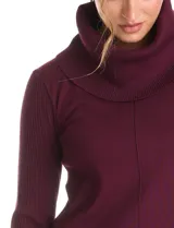 Buzo de punto color bordó con cuello volcado amplio y mangas largas. Presenta una costura central vertical en el frente y diseño con tajos laterales en el ruedo, siendo ligeramente más largo en la parte posterior.