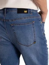 Pantalón de jean azul con corte slim, diseño clásico de cinco bolsillos, cierre de cremallera y botón metálico.