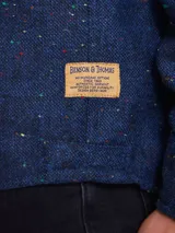 Overshirt de textura tipo tweed en color marrón, con cuello clásico, cierre frontal de botones y bolsillo en el pecho.