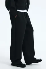 Pantalón tipo jogger de corte relajado con efecto neopreno, cintura elástica con cordón ajustable, bolsillos laterales al bies y bolsillo de parche en la parte trasera.