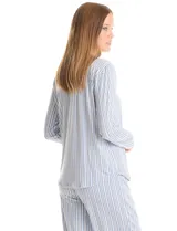 Conjunto de pijama compuesto por una remera de manga larga con escote en V, abertura frontal con botones y bolsillo aplicado, y un pantalón con cintura elástica y lazo de ajuste. Presenta un estampado animal print en tonos neutros.