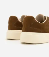 Championes de cuero nobuk en color marrón, con cordones elásticos y suela alta de goma en tono marfil.