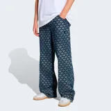 Pantalón Adidas Originals de corte holgado (baggy fit) con estampado integral de monograma del logo Trefoil. Confeccionado en tejido denim, presenta un diseño de pierna ancha y tiro medio.