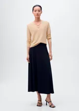 Jersey de punto fino color beige claro, con escote en V y mangas largas.