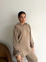 Canguro de tejido acanalado color bordó, con capucha, mangas largas abullonadas y corte holgado.