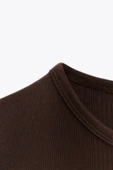 Camiseta de manga corta y cuello redondo, color crema, con tejido acanalado (rib) y corte ajustado (slim fit).