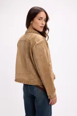 Campera de gamuza color tostado, con diseño de cuello camisero y cierre frontal. Presenta detalles de tachas metálicas doradas en el cuello, a lo largo de la solapa y en la parte superior delantera.