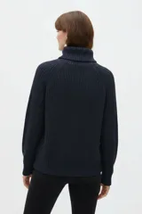 Polera de algodón azul marino, de punto inglés, con cuello alto vuelto, mangas largas ranglán y calce holgado.