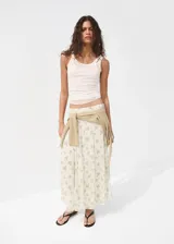 Falda midi evasé de color blanco con estampado floreado en tonos azules y verdes. Cuenta con cierre lateral y forro interior.