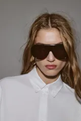 Camisa de corte oversize con cuello solapa, manga larga con puños y bajo asimétrico. Cierre frontal con botones.