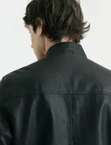 Campera de cuero ecológico con cierre frontal metálico y cuello mao.