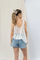 Musculosa blanca de encaje calado con diseño floral, escote en V y breteles anchos.