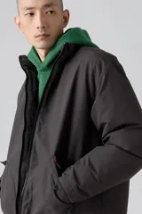 Campera puffer corta color gris oscuro, con cierre frontal y dos bolsillos con solapa y botón.