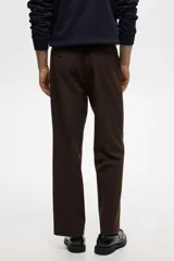 Pantalón de corte relajado color marrón, con cierre de botón, cintura con elástico y cordón interno, bolsillos laterales al bies y bolsillos traseros ribeteados con botón.