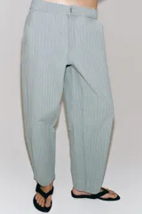 Pantalón de tiro medio confeccionado en hilatura con mezcla de algodón, con diseño de rayas diplomáticas. Presenta bolsillos laterales ocultos en costura, pierna ancha y cierre frontal con cremallera y botón.