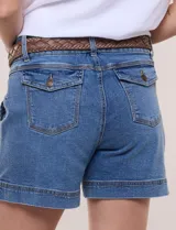 Short de denim azul con bolsillos frontales aplicados, pretina con pasadores, cierre y botón. Incluye un cinturón trenzado de cuero marrón.