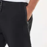 Pantalón de chándal tipo jogger de punto piqué, color negro, con cintura elástica y puños acanalados en los tobillos.
