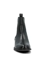 Bota tipo Chelsea de cuero negro, con paneles elásticos laterales y tirador en la parte trasera. Presenta un diseño de caña media con suela plana y taco bajo cuadrado.