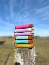 Billetera pequeña con cierre metálico, cuerpo principal en tejido texturizado color fucsia y detalles en cuero marrón con textura de reptil. Posee un parche de cuero claro con la palabra "chowie" escrita a mano.