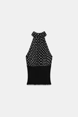 Top de cuello halter con hombros descubiertos, confeccionado con una combinación de tejidos. La parte superior presenta un estampado de lunares, mientras que la parte inferior es de tejido liso acanalado.