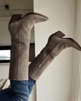 Bota de caña media color marrón chocolate, de gamuza, con punta fina y taco cónico.